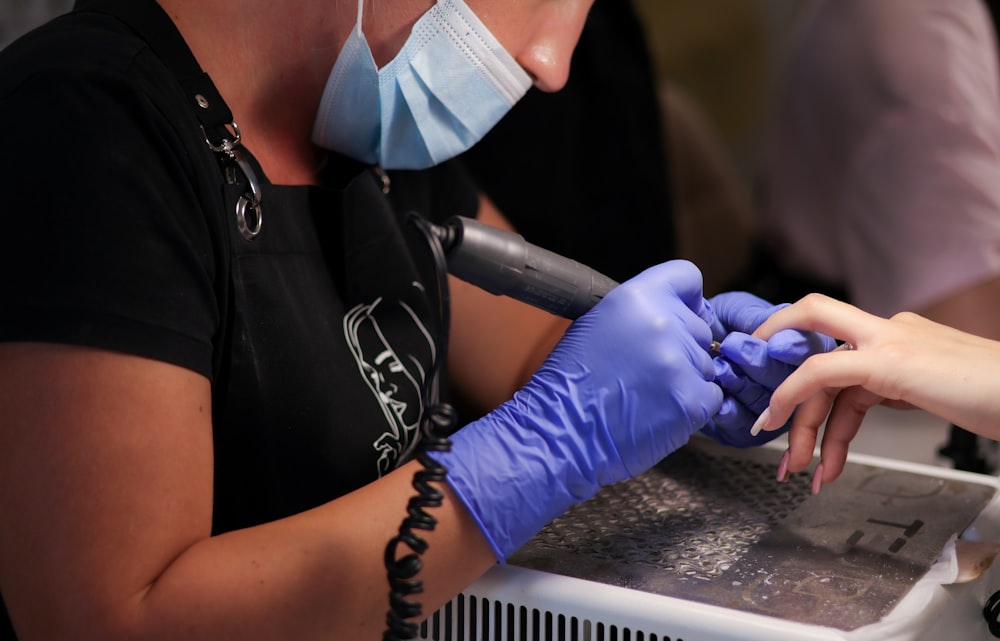 a woman in a black shirt and purple gloves