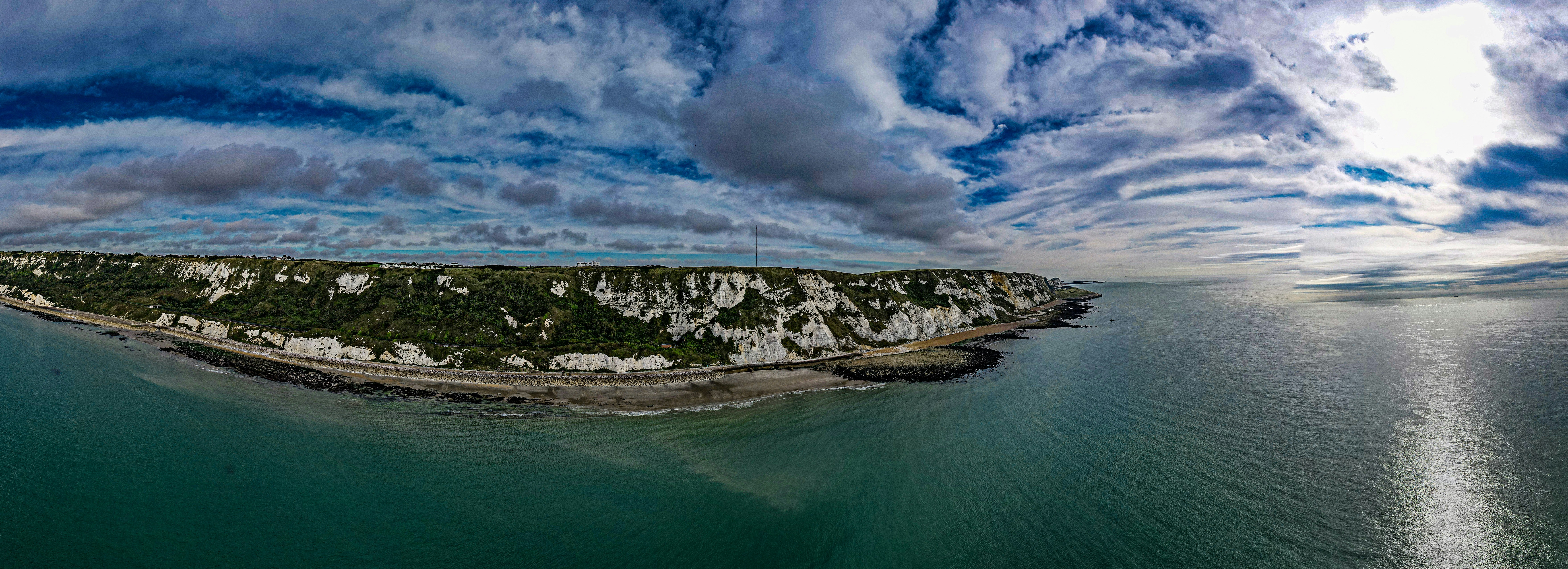 an island in the middle of the ocean under a cloudy sky, White cliffs of Dover