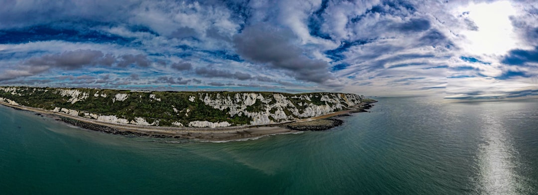 an island in the middle of the ocean under a cloudy sky, White cliffs of Dover