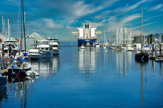 a harbor filled with lots of boats under a cloudy blue sky