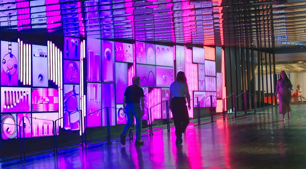 a group of people walking down a walkway next to a building