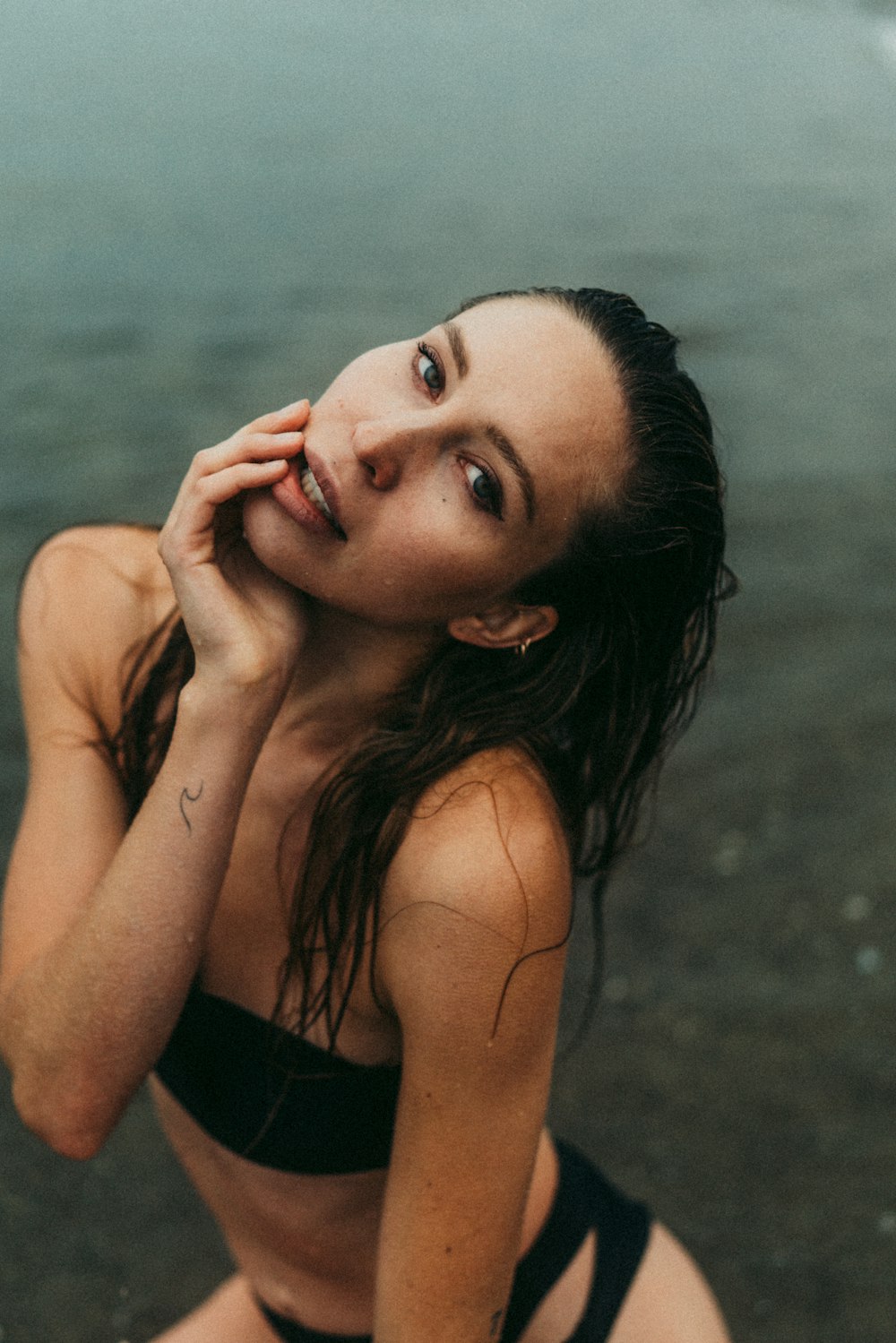 a woman in a bikini sitting on the beach