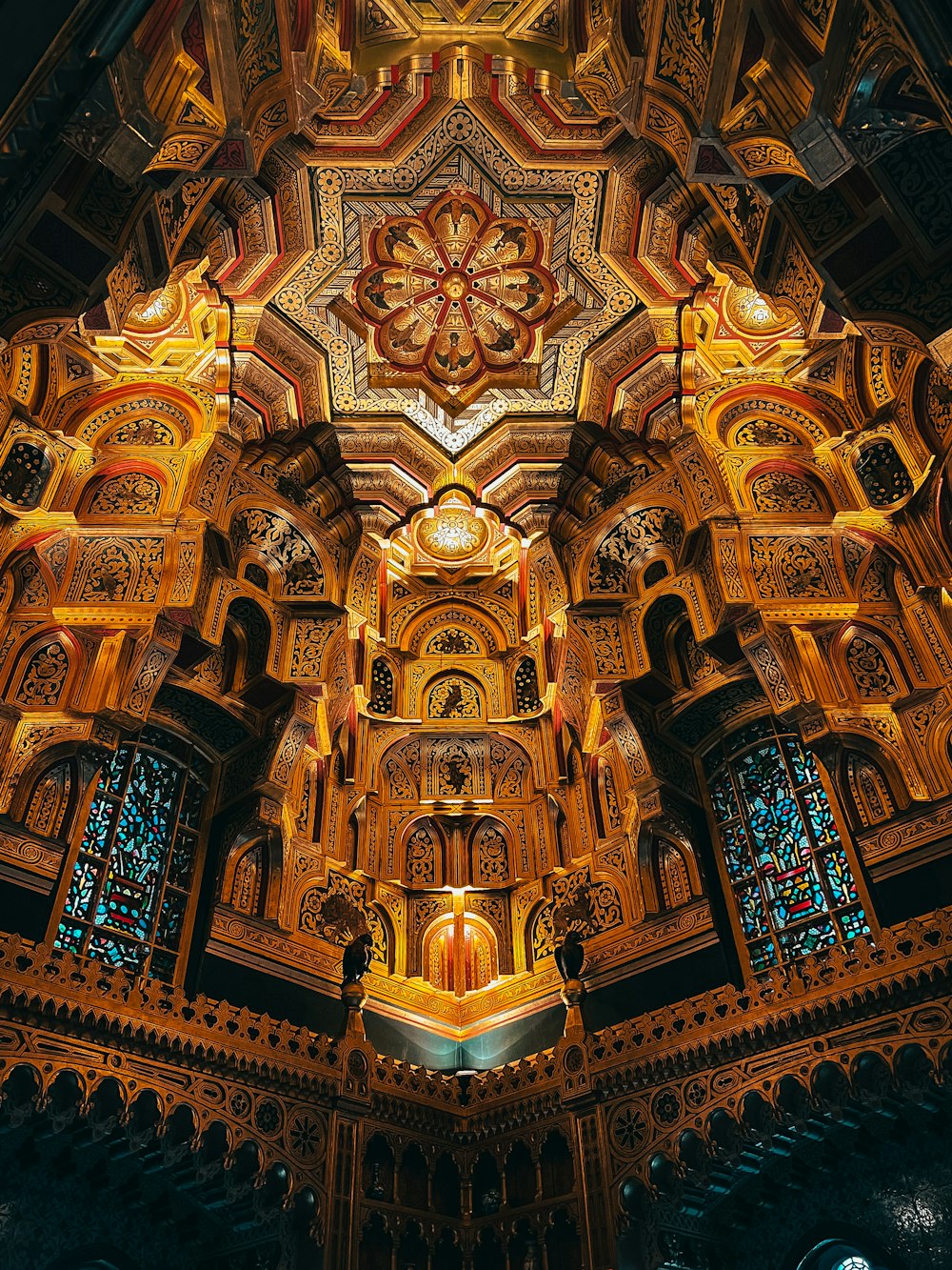 the ceiling of a church with intricate carvings and stained glass windows