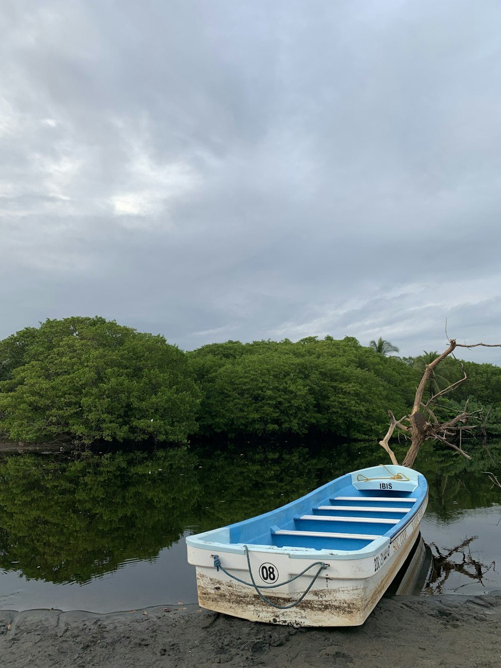 a blue and white boat sitting on top of a beach