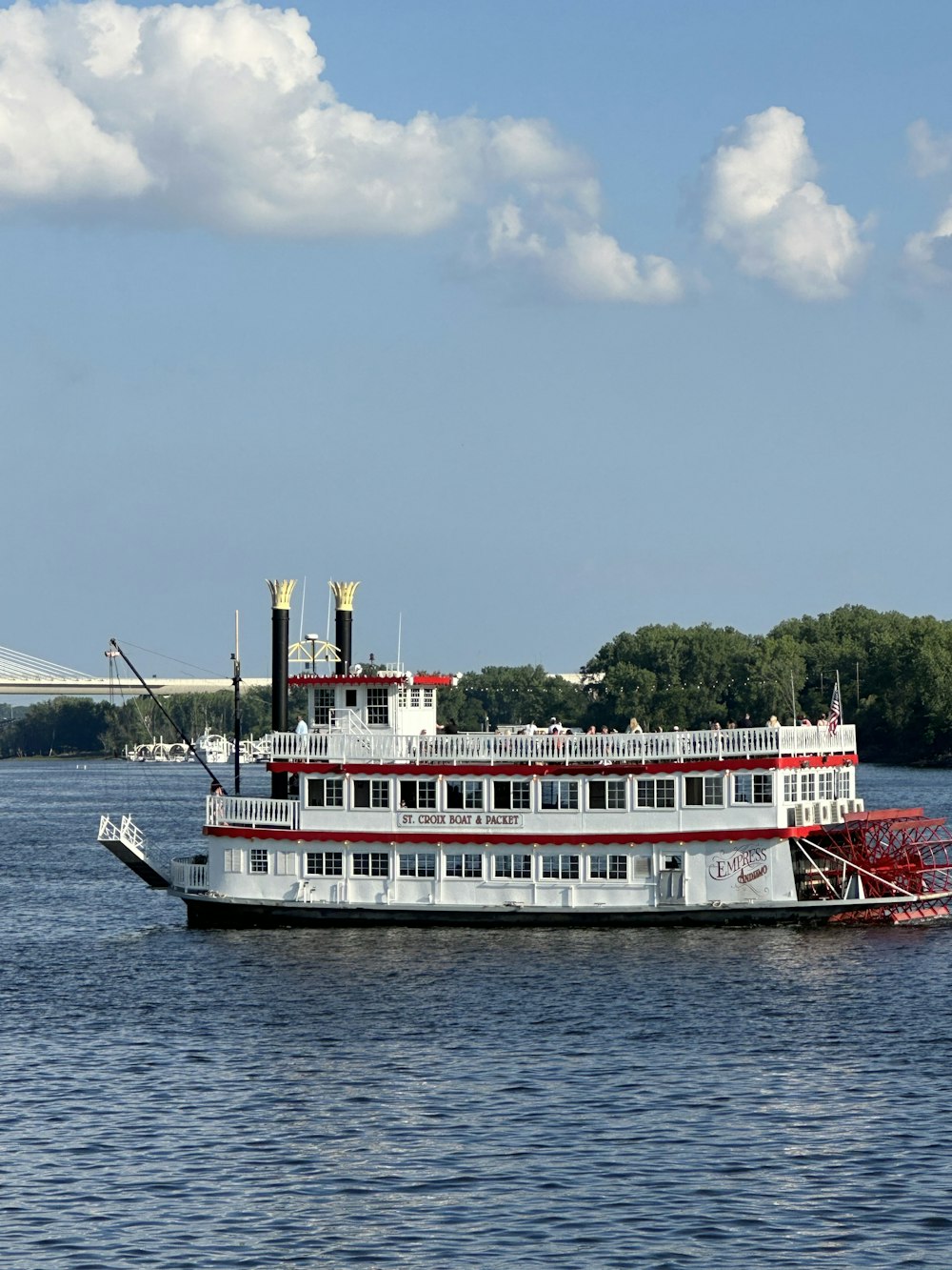 a large white and red boat floating on top of a body of water