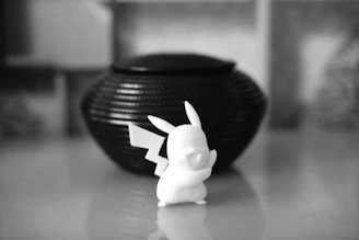a black and white photo of a small figurine