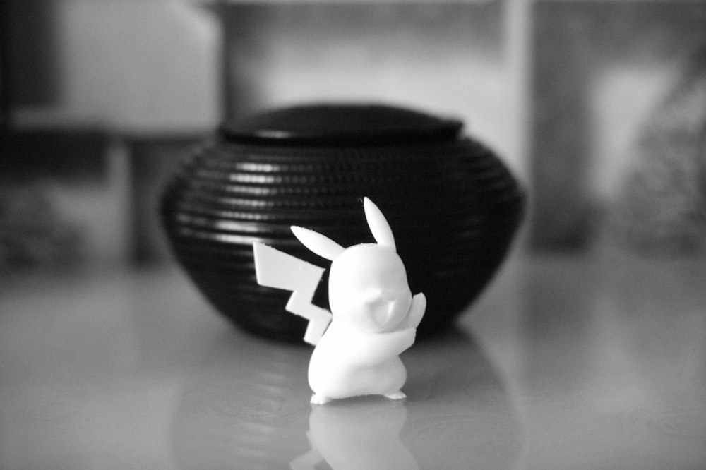 a black and white photo of a small figurine