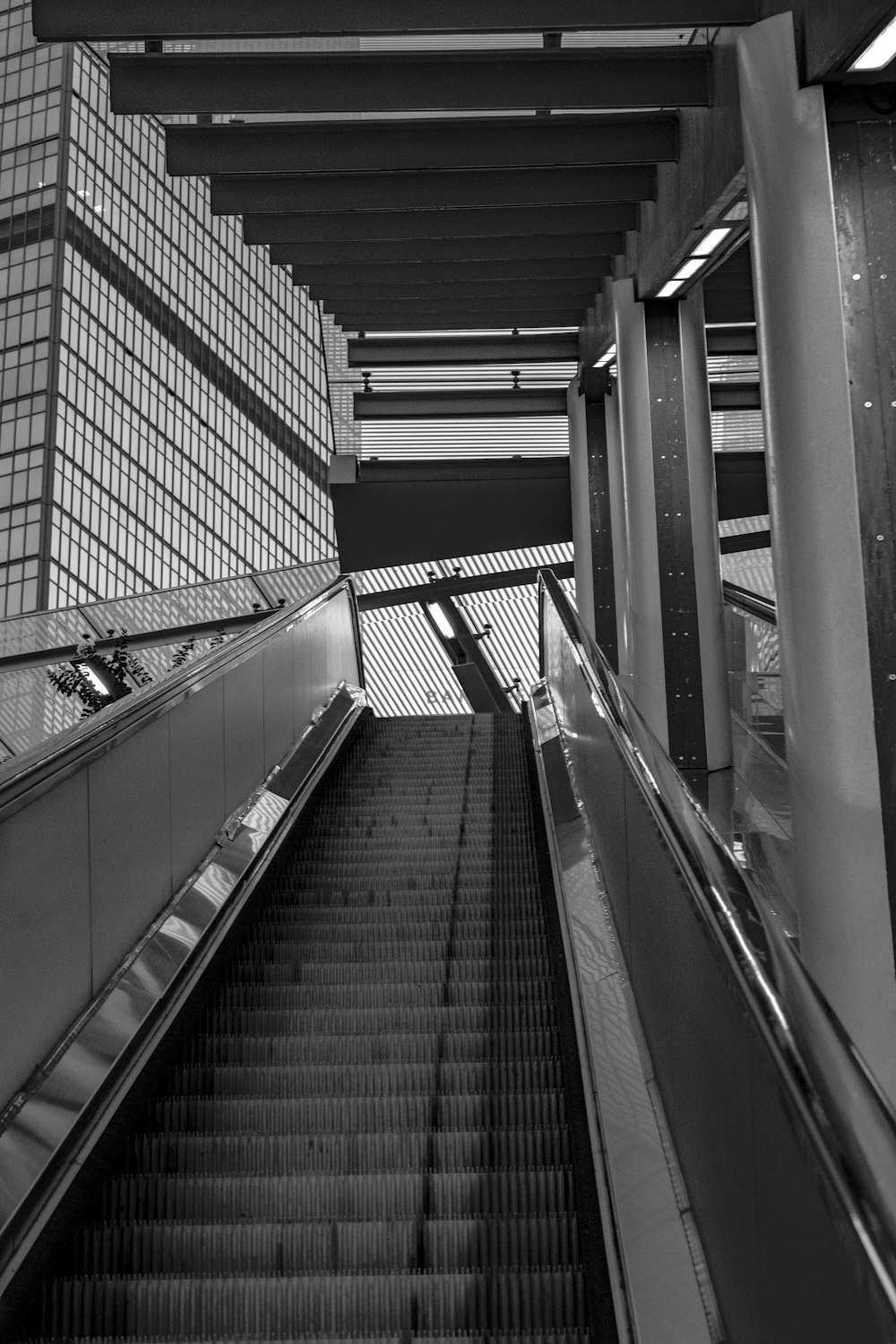 a black and white photo of an escalator