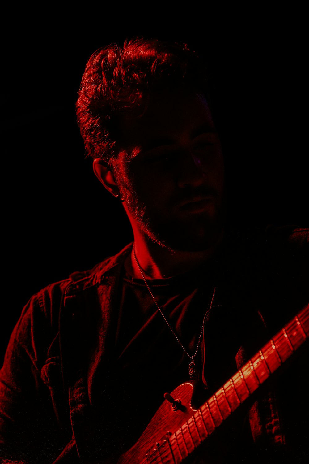 a man playing a guitar in the dark