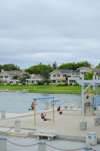 Children playing safely on swings and slides under a sunny sky.