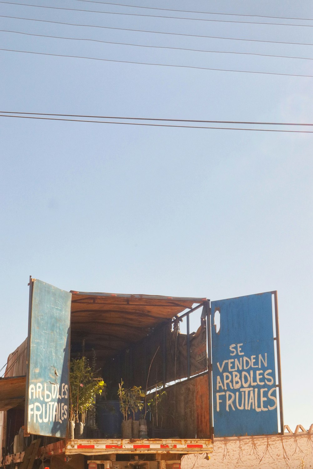 a truck with a trailer carrying plants on the back of it