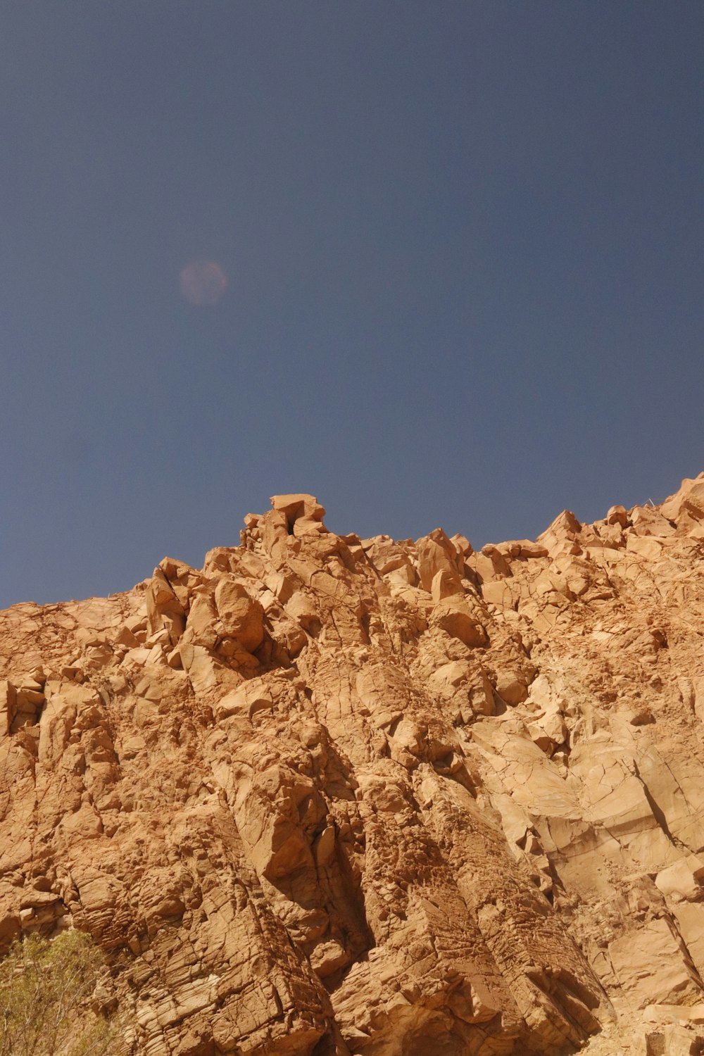 a large rock formation in the desert under a blue sky