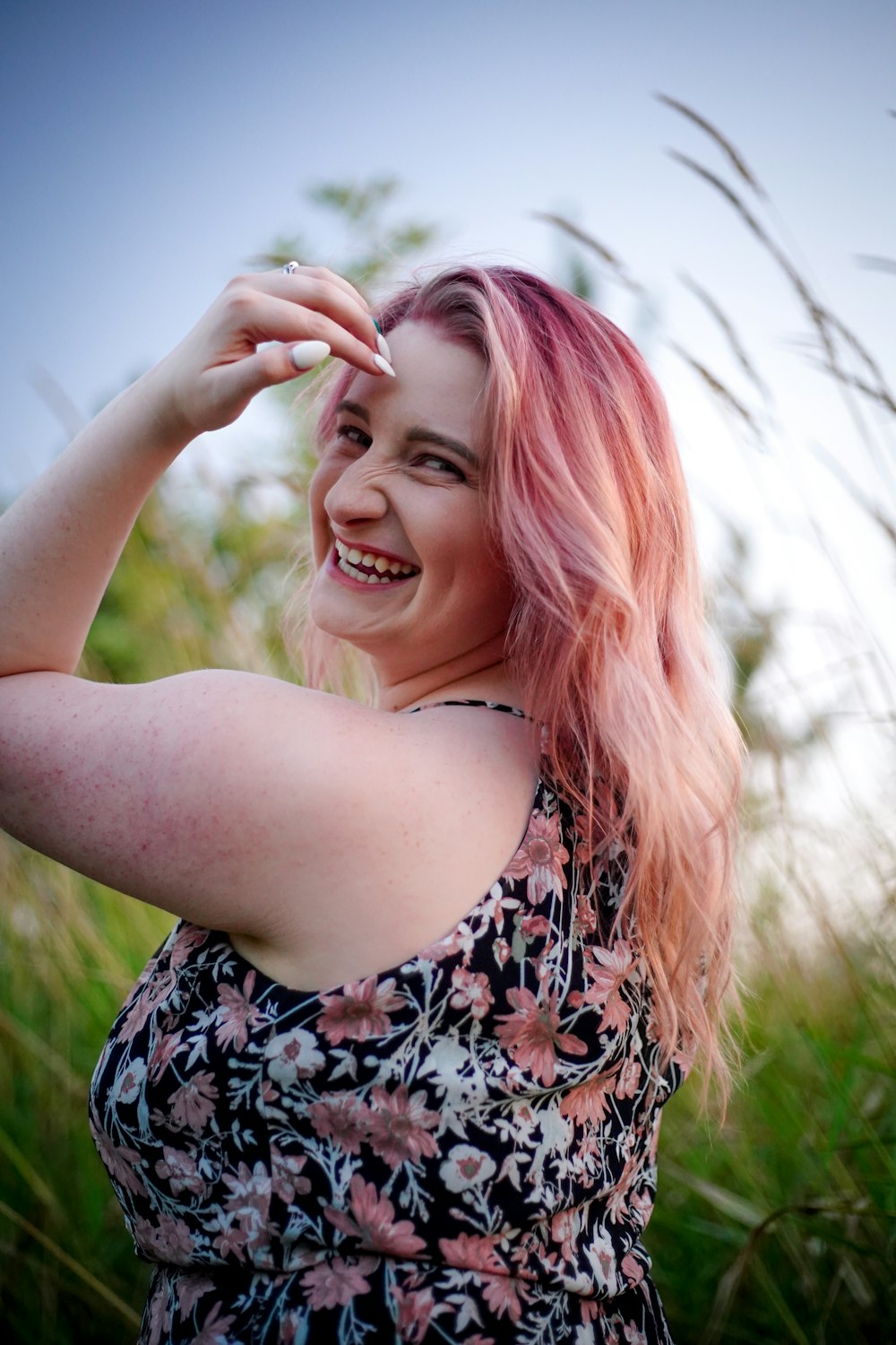 a woman with pink hair is posing for a picture