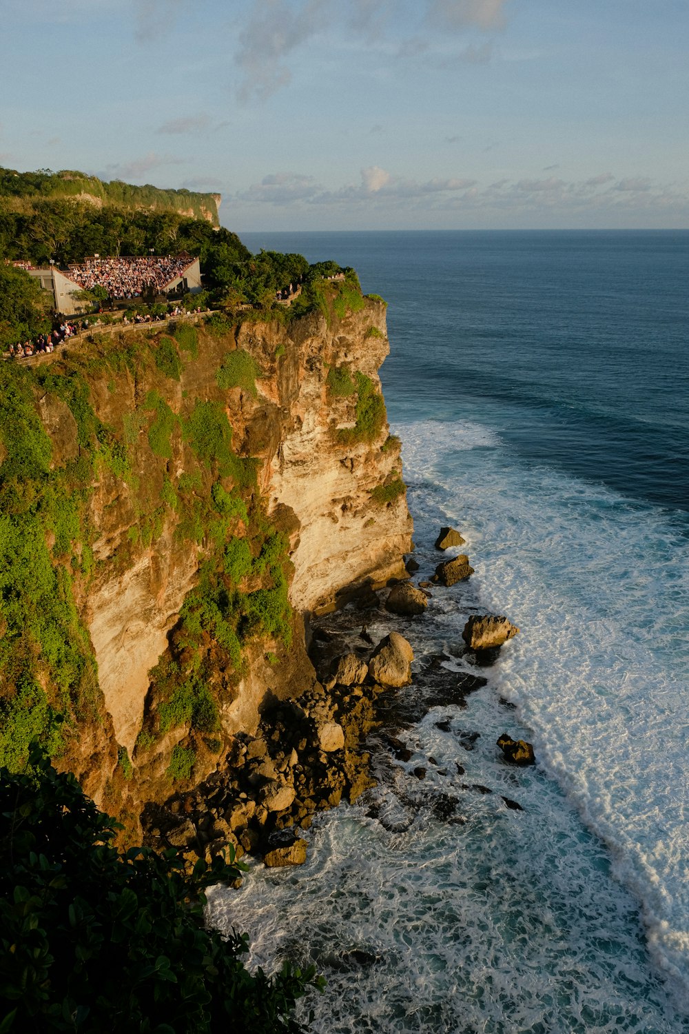 a cliff overlooking the ocean with people on it