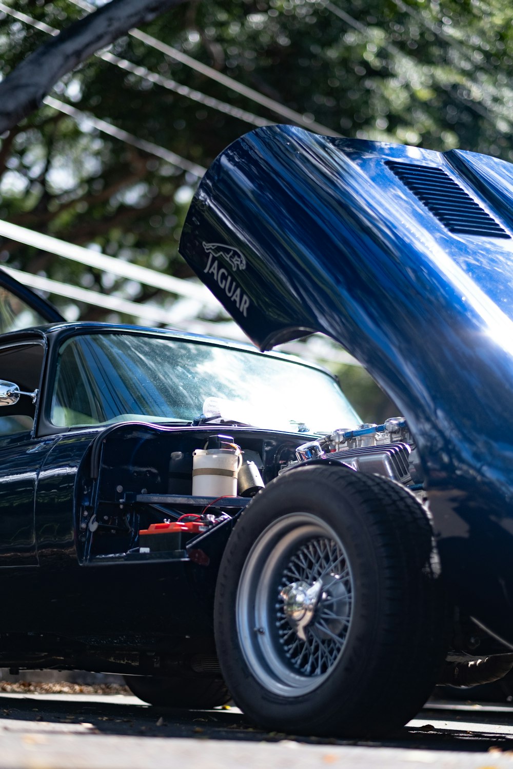 a blue car parked next to another car on a street