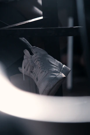 Close-up of a sleek black Nike sneaker with white accents on a dark background.