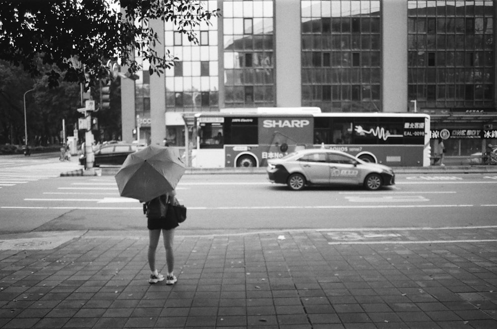 a woman holding an umbrella on a city street