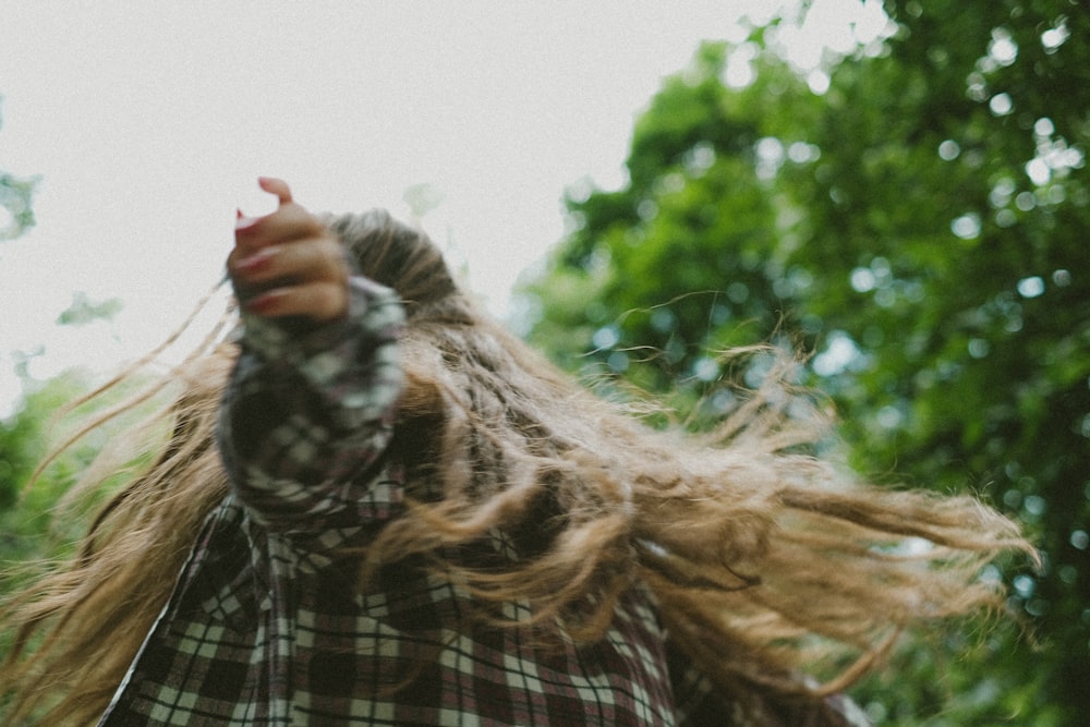 a person with long hair holding a cell phone