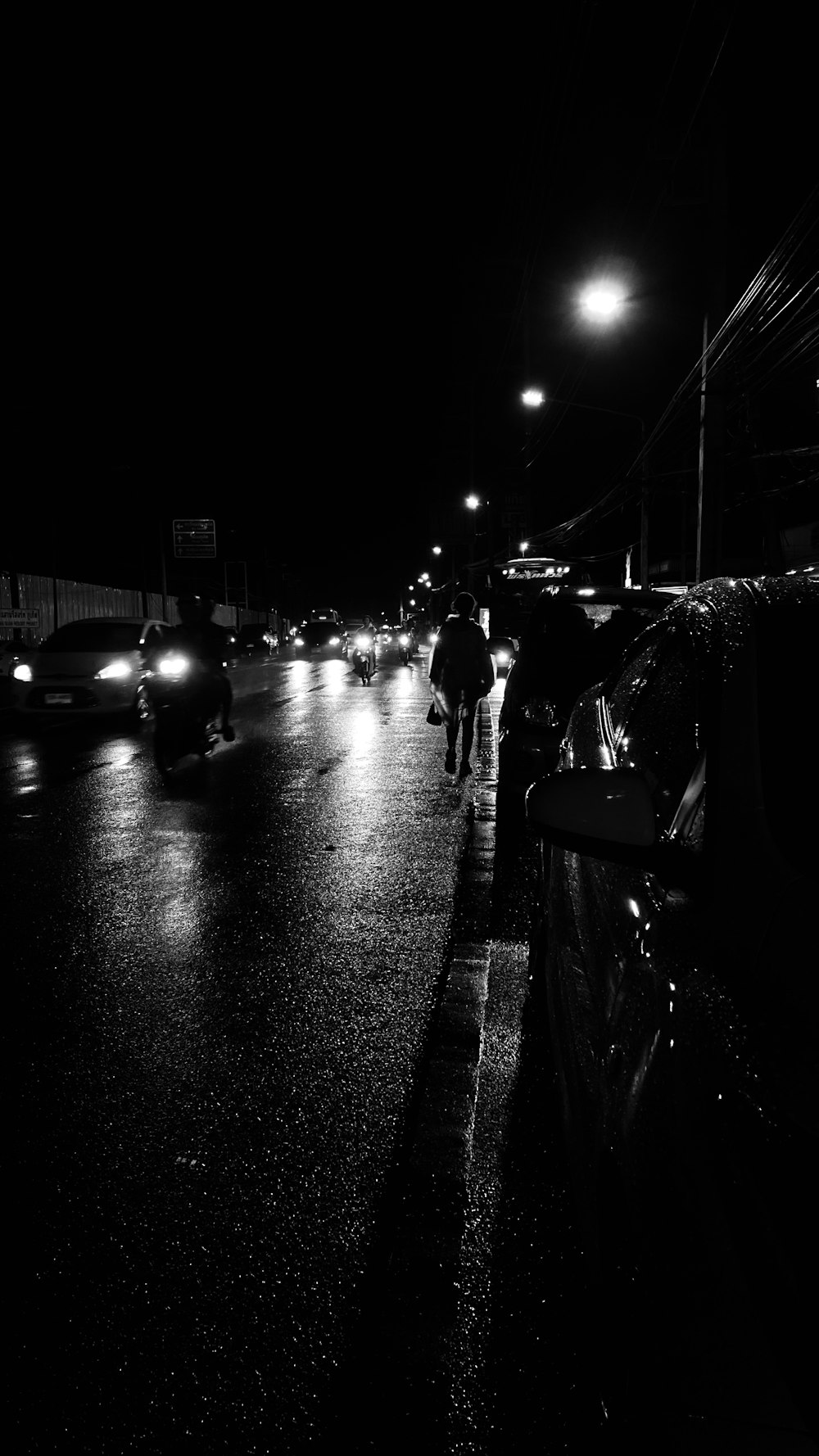 a group of people walking down a street at night