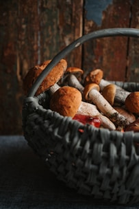 A rustic basket filled with vibrant shiitake mushrooms on a wooden table.