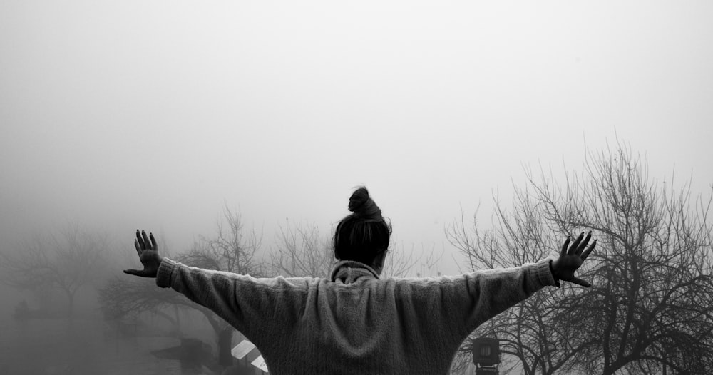 a black and white photo of a man with a bird on his shoulders