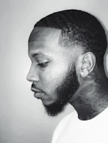 A side profile of a client sporting a sharp line-up and a well-groomed beard finished at knipkunst.