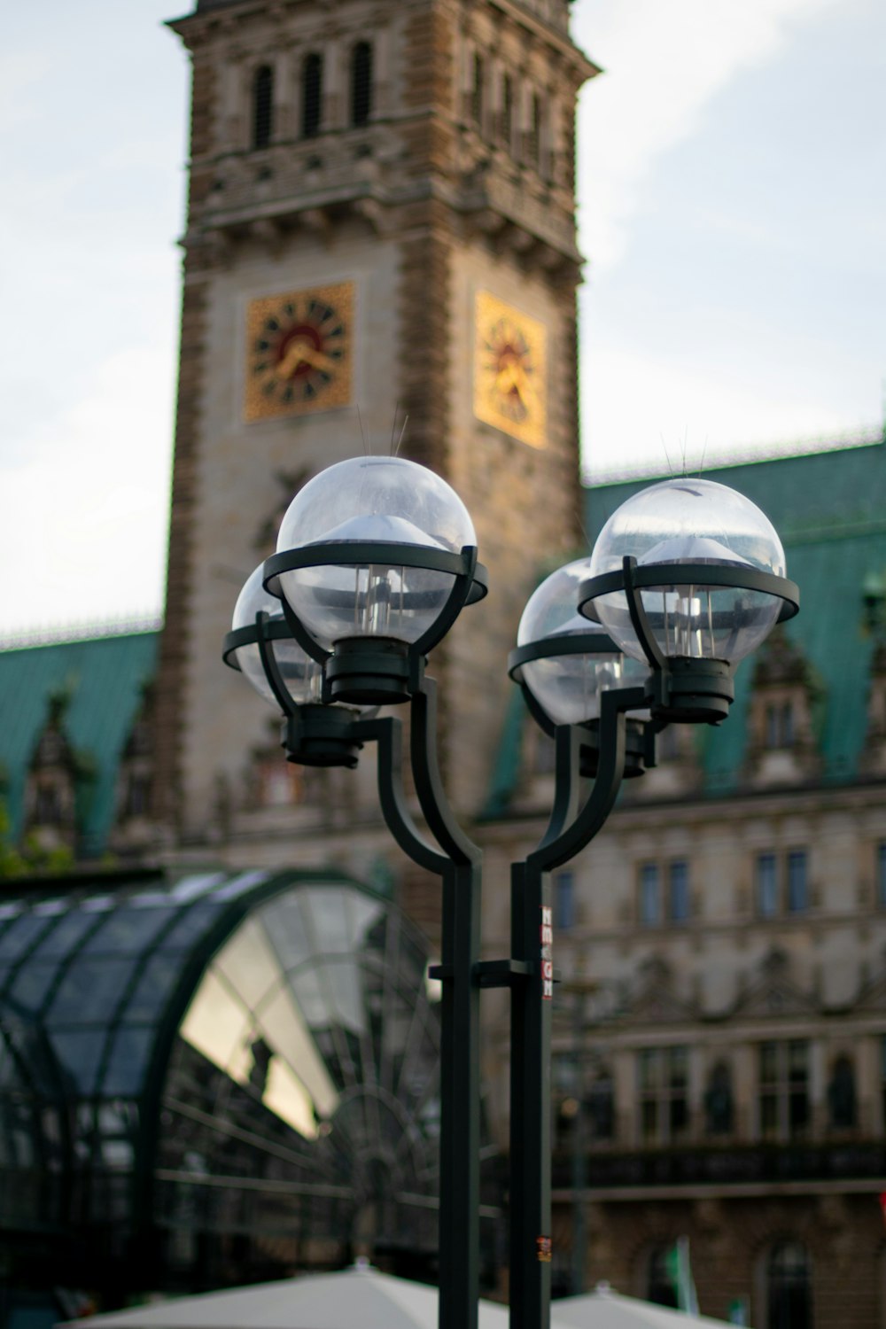 a street light with a clock tower in the background