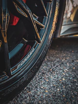 Dynamic shot of a vehicle showcasing both forged wheels and the valved exhaust in action.