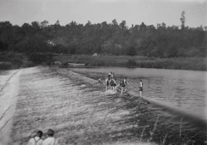 Children playing near a small river with wooden footbridges