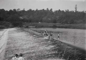 Children playing near a small river with wooden footbridges