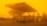 A gas station with the logo 'IndianOil' appears amid an intense yellow-orange haze, likely caused by a sandstorm or heavy pollution. The sky and surroundings are enveloped in this thick hue, significantly reducing visibility. The gas pumps are visible under the shelter, and there's a building in the background with a solar panel on its roof.