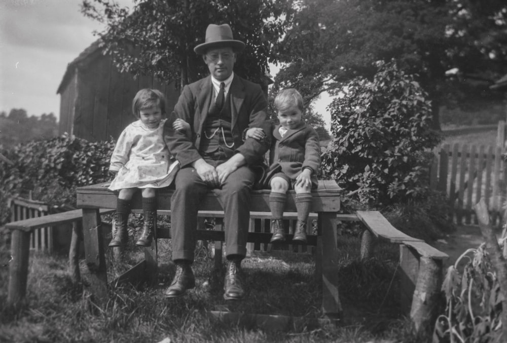 a man and two children sitting on a bench