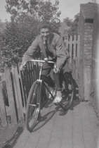 Murdered by Darkness Image a man riding a bike down a sidewalk next to a fence