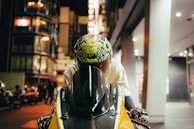 A biker wearing Moto Man gloves, gripping the handlebar with the Mumbai skyline in the background.