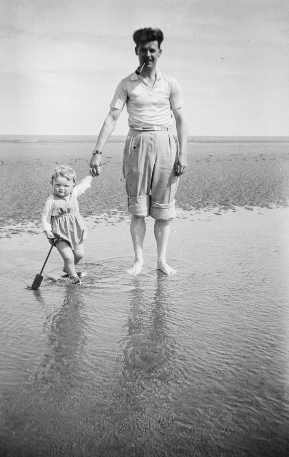 an old photo of a woman holding a child's hand