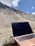 A cheerful freelancer working on a laptop with Swiss mountains visible through the window.
