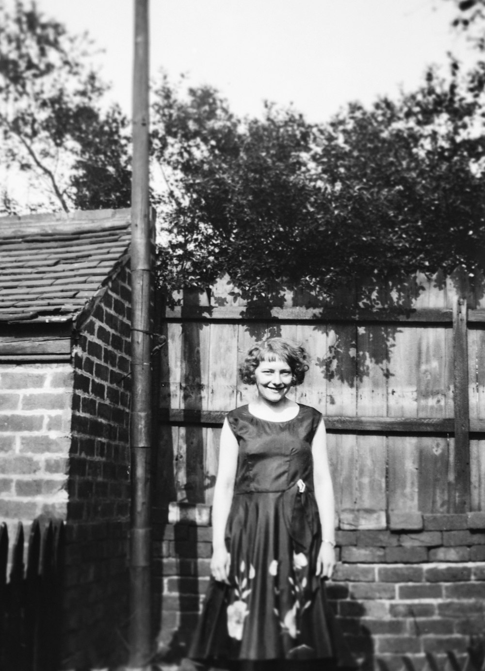 a woman standing in front of a brick wall