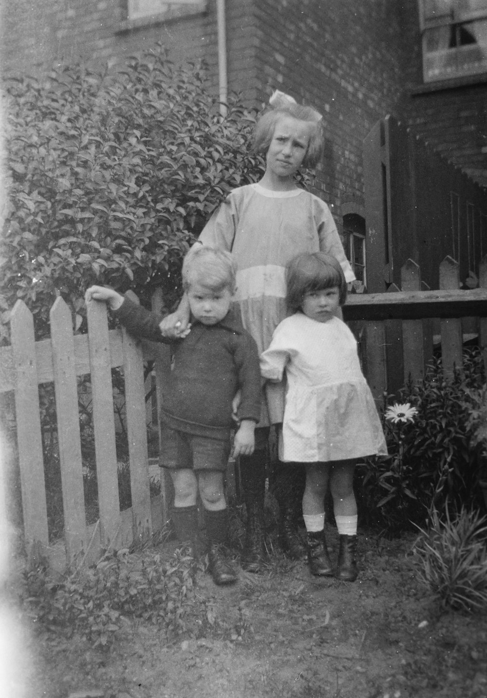 a black and white photo of three children