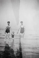 an old photo of a man and a woman holding a child's hand