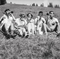 A group of friends enjoying a picnic on a grassy knoll.