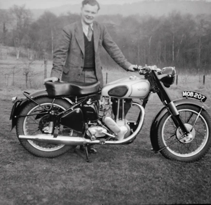 Murdered by Darkness Image  a man in a suit standing next to a motorcycle