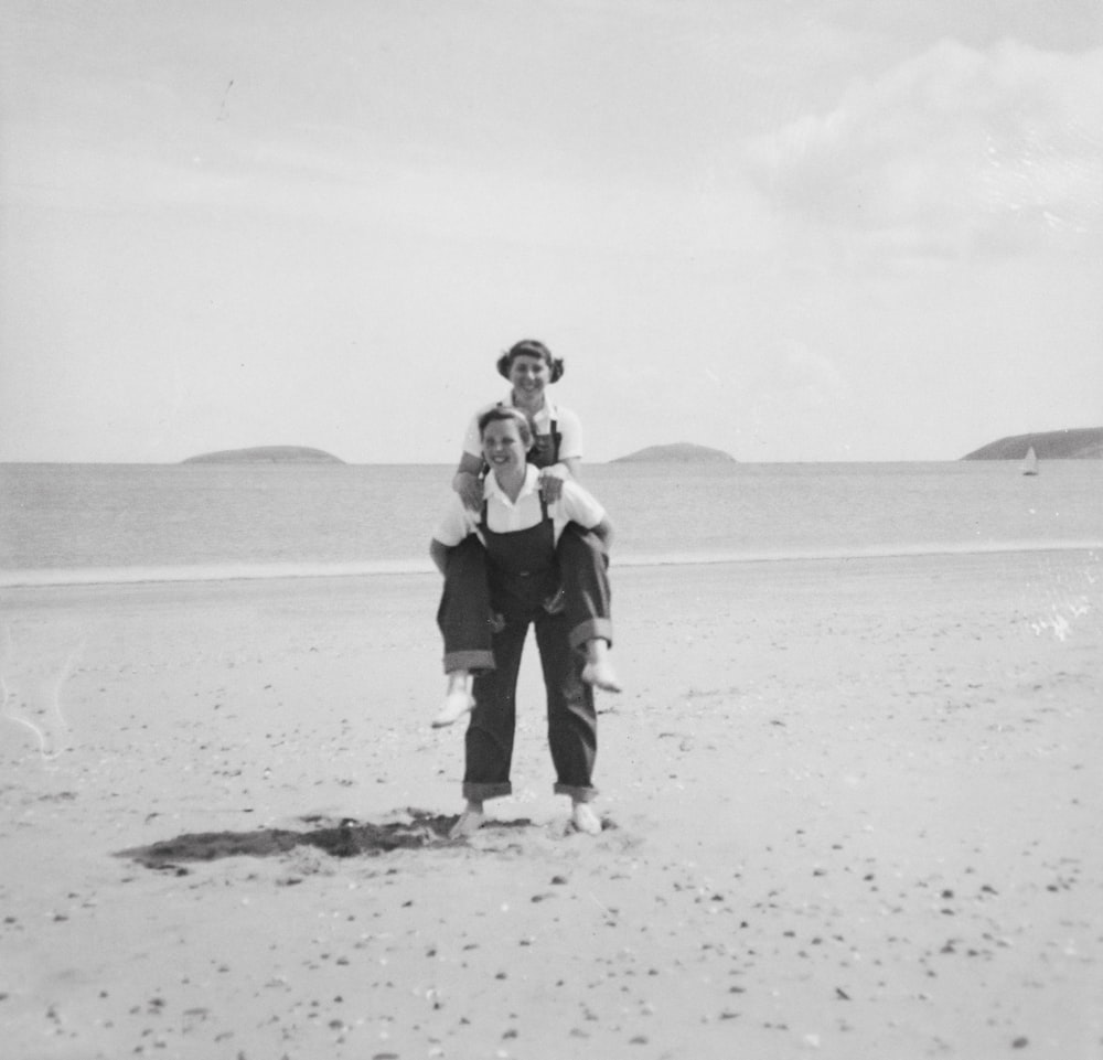 a woman holding a child on the beach