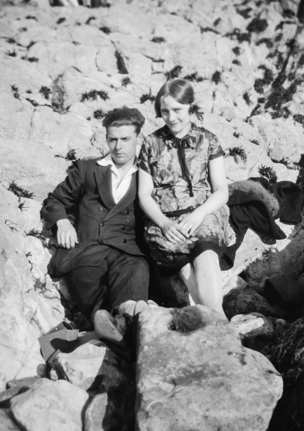 a man and a woman are sitting on rocks