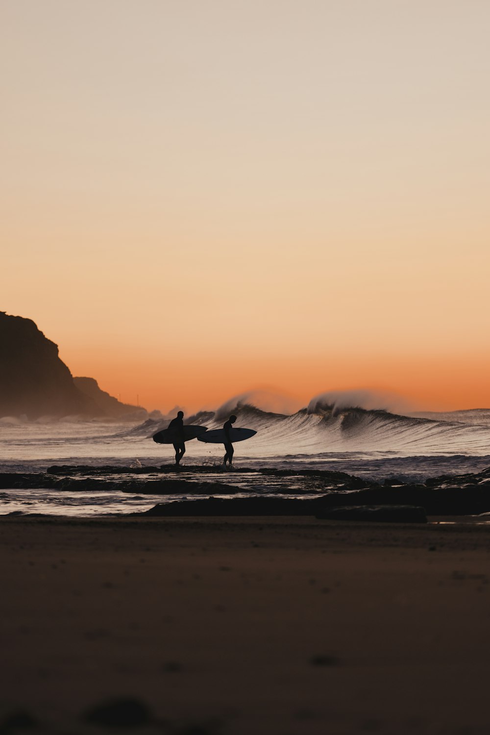 a person holding a surfboard on top of a beach