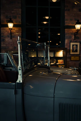 A sleek, vintage car parked inside a dimly lit, exclusive vault room.