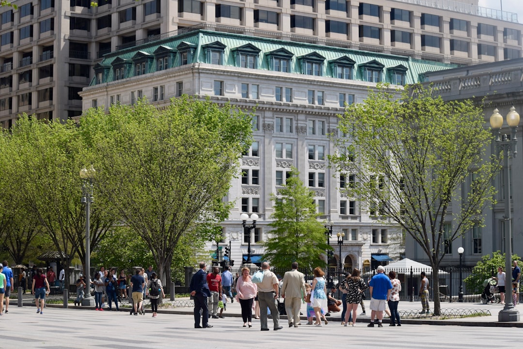 a group of people walking down a street next to tall buildings