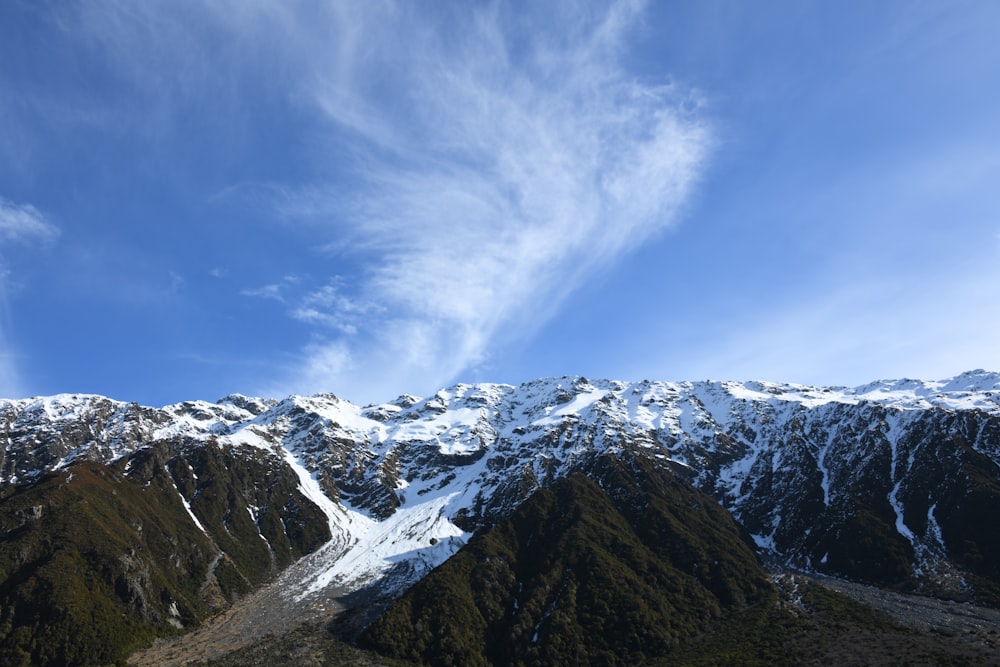 a snow covered mountain range under a blue sky