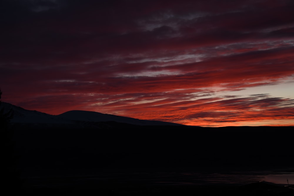 a sunset with a mountain in the background