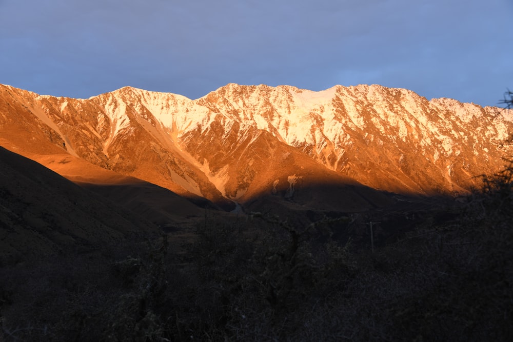 the sun is setting on a mountain range