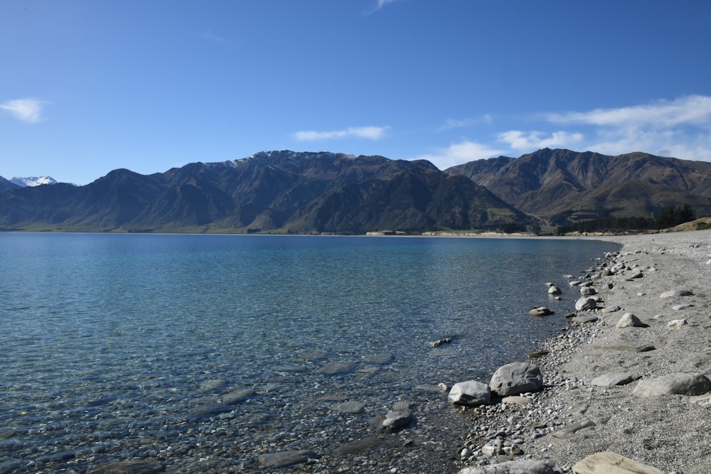 a body of water with mountains in the background